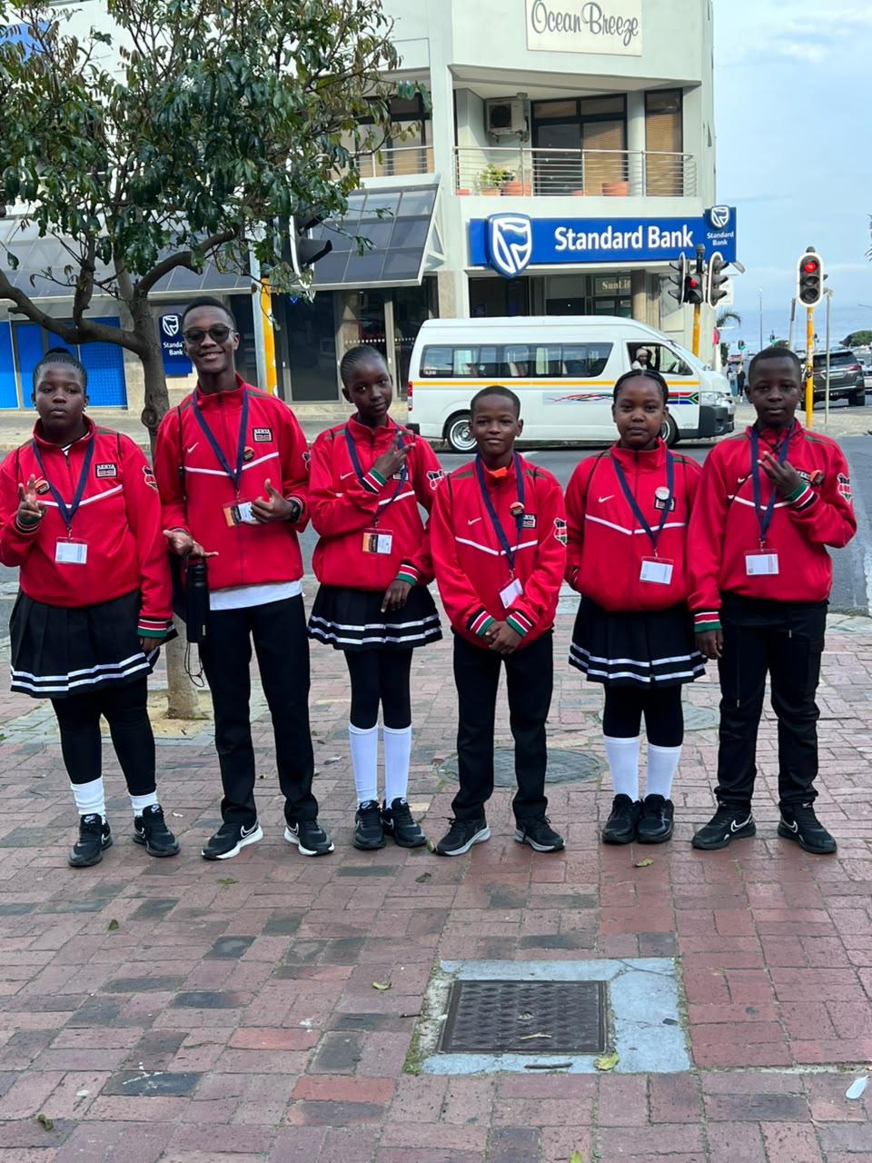 Young Kenya team members in red tracksuits on a Cape Town street