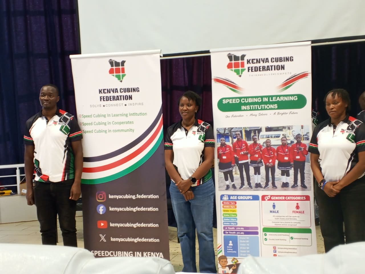 Kenya Cubing Federation representatives standing beside event banners