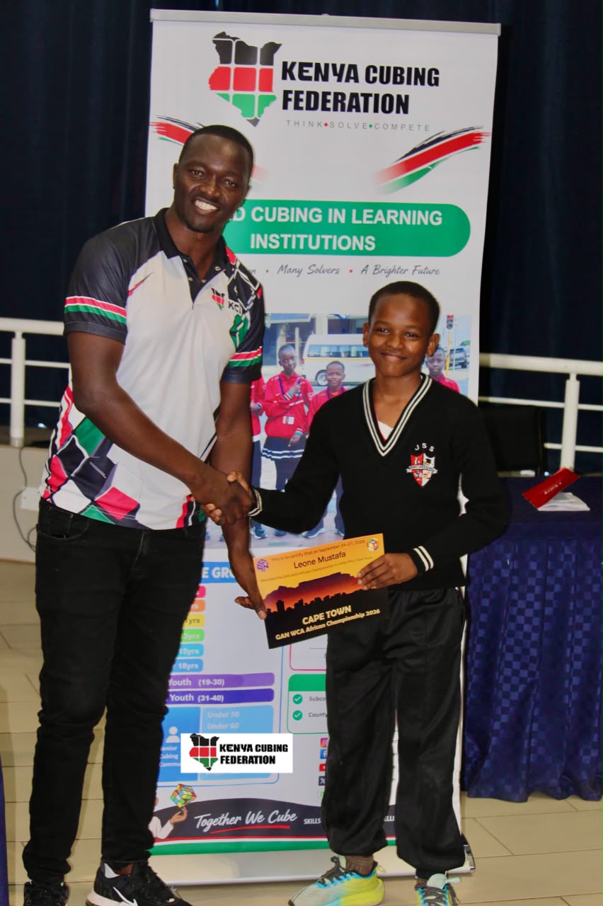 A young competitor receives an award beside a Kenya Cubing Federation representative